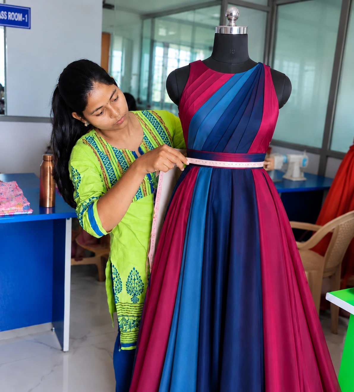 Fashion design student draping magenta fabric on a dress form at Shanas Institute, Trichy